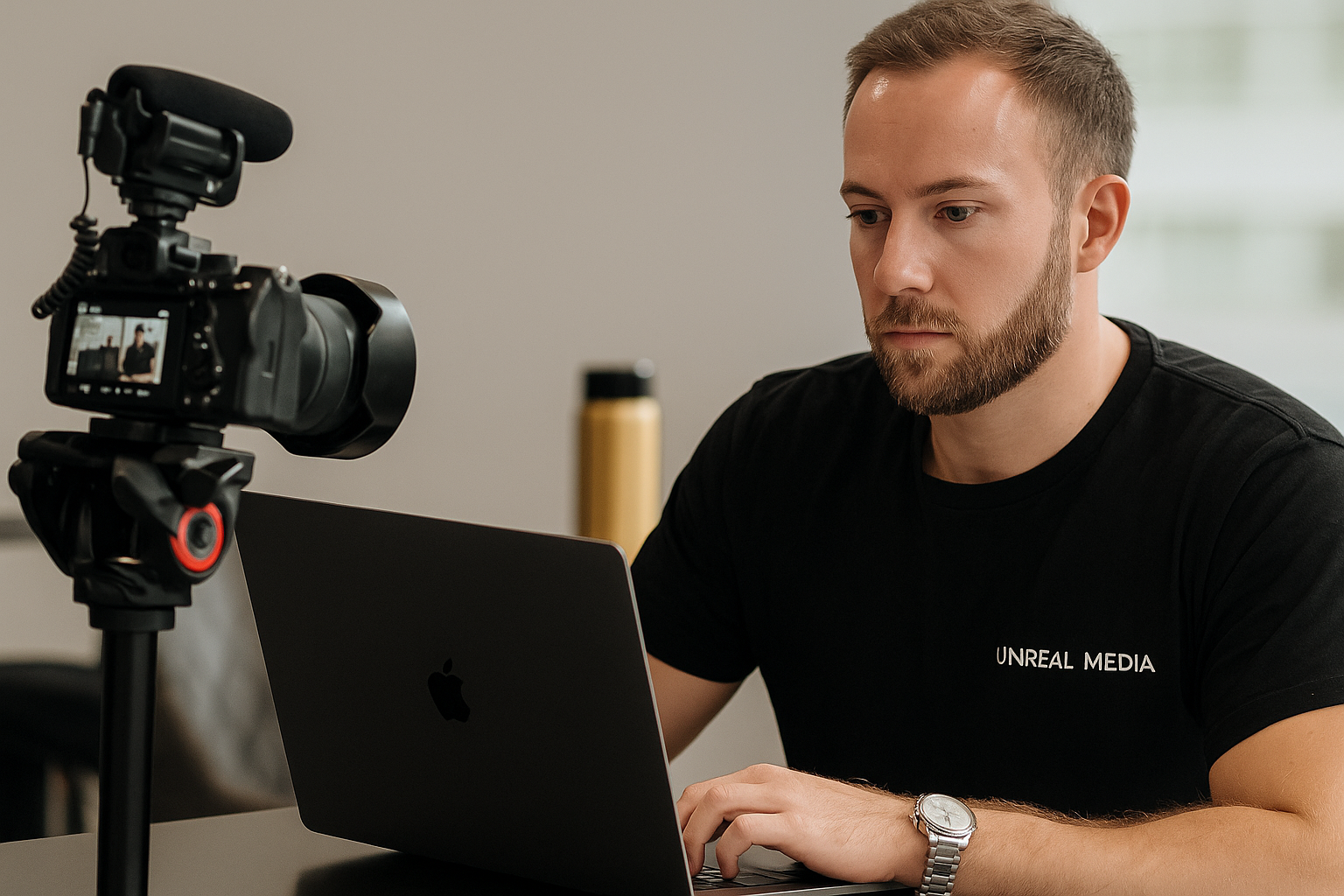 Videographer in a black Unreal Media shirt setting up a camera in a Brisbane studio